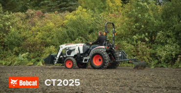 Tracteur compact blanc Bobcat CT2025 avec chargeur frontal travaillant sur un terrain à Rouyn-Noranda.